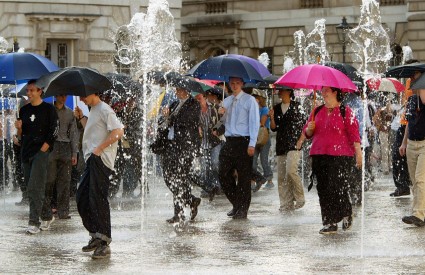 Londonsko okupljanje, gdje su ljudi s kišobranima hodali kroz fontanu