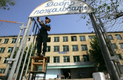 Radnik postavlja znak dobrodošlice na školi u Tskhinvaliju